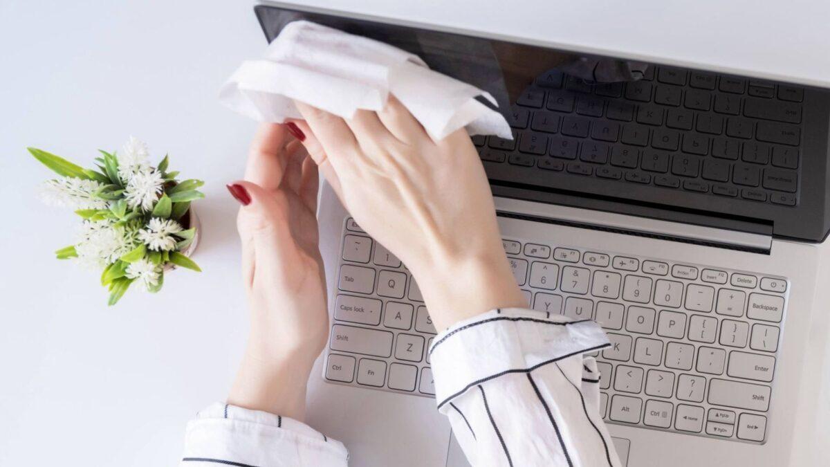 Người đang dùng khăn microfiber lau màn hình laptop