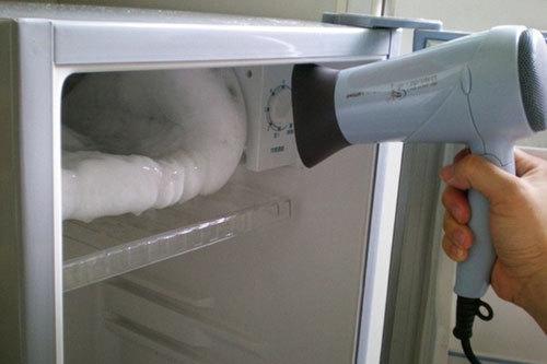 Dùng máy sấy tóc làm nóng vết sáp qua lớp giấy